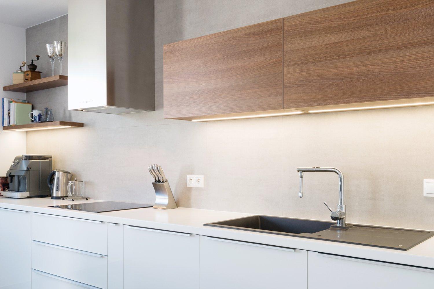 Kitchen area with built-in stovetop, white lower cabinets, and wood upper shelving