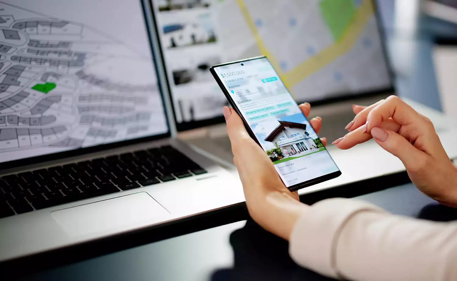 Person Shopping for a Home Using a Phone and Laptop